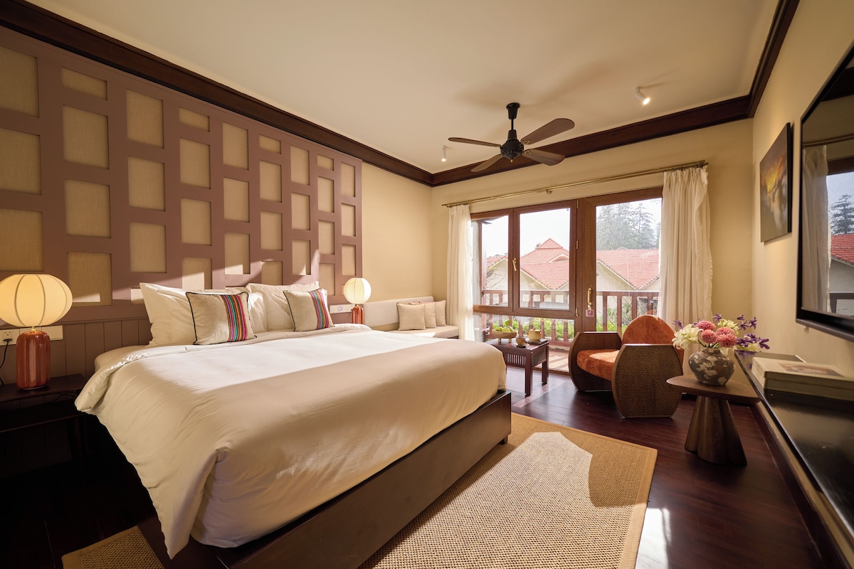 A spacious bedroom with a large bed, a ceiling fan, and a view of the outside.