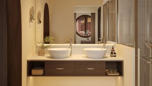 A modern bathroom with two large sinks, a mirror, and a shower area.