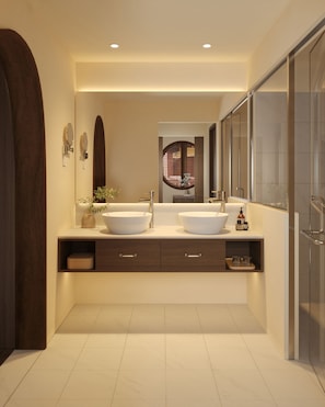 A modern bathroom with two large sinks, a mirror, and a shower area.