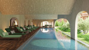 A pool area with lounge chairs and a view of a building.