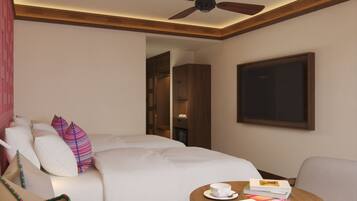 A hotel room with a bed, a seating area with a table, a ceiling fan, and a door leading to another room.