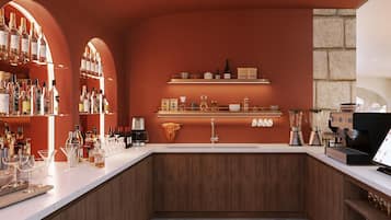 Zona de bar con estanterías llenas de botellas, vasos y una máquina de café.