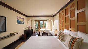 Habitación de hotel con una cama grande, televisor, escritorio y vistas al exterior.