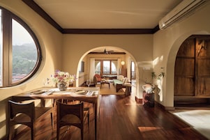 Un comedor amplio con un gran ventanal, suelo de madera y vistas al exterior.