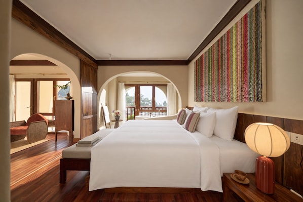 A hotel room with a large bed, a desk, a chair, and a view of the outdoors. - The Myst Sapa Resort (Sa Pa)