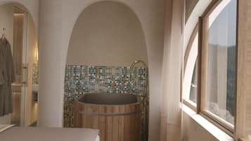 A modern bathroom with a bathtub, a toilet, and a shower area.