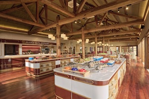 A buffet area with a variety of food options, a sign reading 'HANOI SAPA EXPRESS', and a wooden ceiling structure.