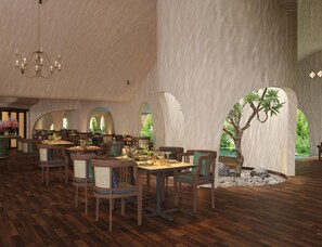 Un comedor amplio con suelo de madera, mesas dispuestas para comer y una araña.