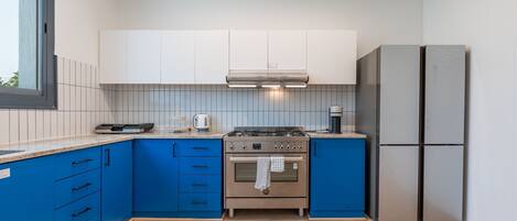 A modern kitchen with a gas stove, oven, and a built-in refrigerator.