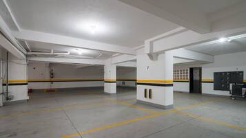 Uma garagem de estacionamento com paredes brancas, faixas amarelas e pretas e vagas numeradas.
