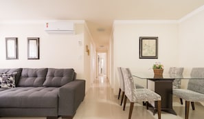 A modern living room with a grey sofa, a dining table with chairs, and framed artwork on the walls. - Apt 150m fr Beach, 3bedroom BC Center Eac1302 (Balneário Camboriú)