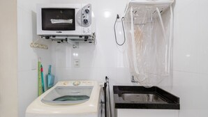 Una cocina funcional con microondas, lavadora y lavaplatos.