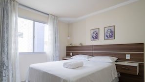 A hotel room with a bed, a nightstand, a lamp, and two framed floral paintings on the wall. - Apt 150m fr Beach, 3bedroom BC Center Eac1302 (Balneário Camboriú)