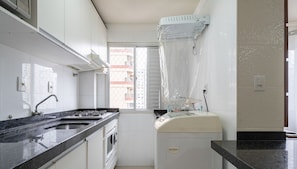 A compact kitchen with a double sink, a stove, and a microwave. - Apt 130m From Beach Balneario Camboriu-sc Eac1303 (Balneário Camboriú)