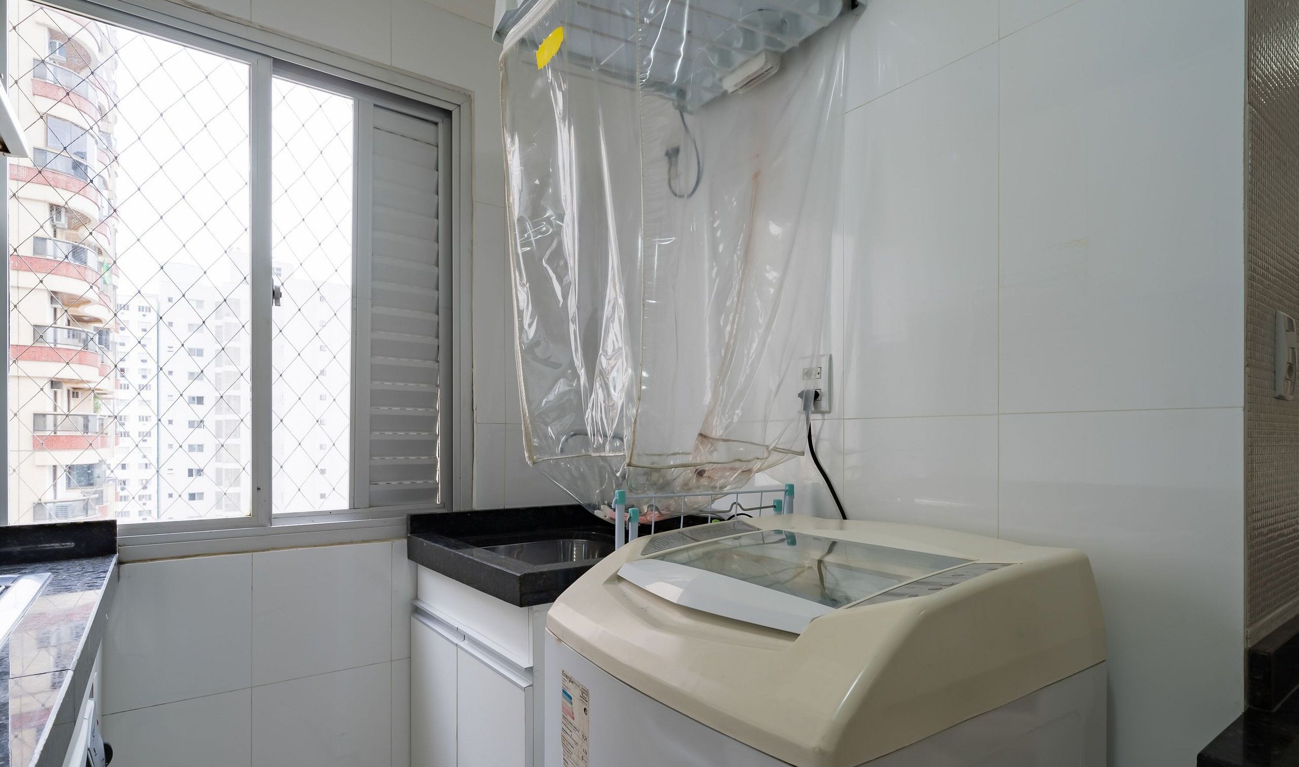 A kitchen with a window, a washing machine, and a countertop.