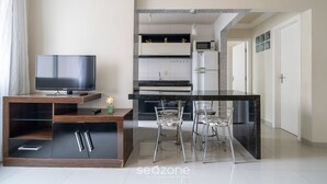 Una cocina moderna con comedor, televisión y una planta pequeña.