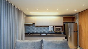 A compact kitchen with a built-in oven, microwave, and refrigerator. - Flat w/ Pool in Setor Bueno - Dnag1701 (Goiânia)