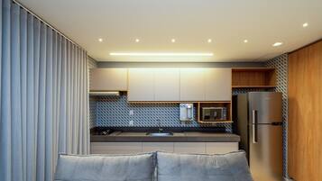 Una cocina moderna con horno empotrado, microondas y refrigerador.