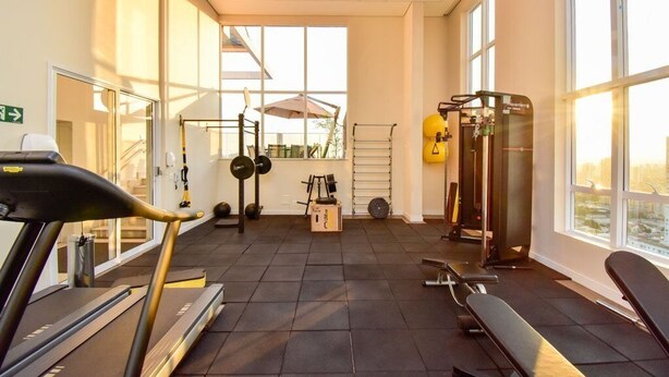 A gym with exercise equipment, a treadmill, and large windows. - Flat w/ Pool in Setor Bueno - Dnag1701 (Goiânia)
