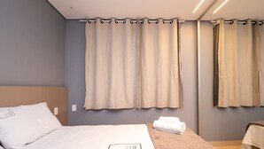 A hotel room with a bed, a nightstand, and a mirror. - Flat w/ Pool in Setor Bueno - Dnag1701 (Goiânia)