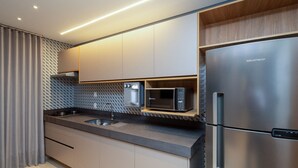 A modern kitchen with a stainless steel refrigerator, a microwave, and a built-in oven. - Flat w/ Pool in Setor Bueno - Dnag1701 (Goiânia)