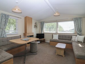 Ein stilvolles Wohnzimmer mit einer Sofagarnitur, einem Fernseher und einem kleinen Tisch.