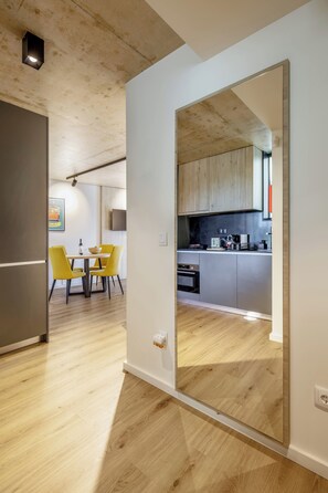 Une cuisine moderne avec des meubles en bois, un coin repas avec des chaises jaunes et un îlot central bien visible.