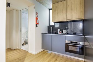A modern kitchen with stainless steel appliances, wooden cabinets, and a marble backsplash. - Marina da Afurada Apartments - Agatha Christie (Vila Nova de Gaia)