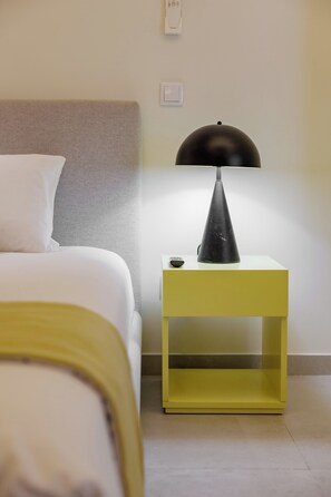 A hotel room with a bed, a bedside table with a lamp, and a wall-mounted light switch. - Marina da Afurada Apartments - Agatha Christie (Vila Nova de Gaia)