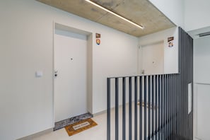 A modern interior with a white door, a black metal barrier, and a welcome mat. - Waterfront Studio w/ Scenic Views, Steps to Dining (Vila Nova de Gaia)