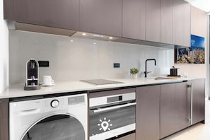 A modern kitchen with a built-in washer, oven, and a coffee maker. - Cozy Studio Smart - Miami Downtown (Miami)