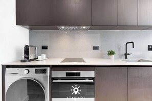 A modern kitchen with a dishwasher, oven, and sink. - Cozy Studio Smart - Miami Downtown (Miami)