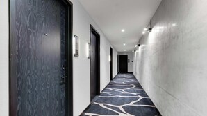 A hallway with patterned carpet, doors, and recessed lighting. - Design Studio - Miami Pulse E11EVEN (Miami)