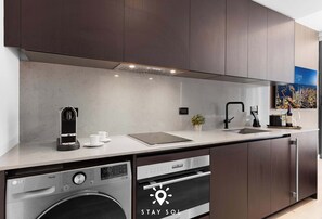 A modern kitchen with a dishwasher, oven, and coffee maker. - Design Studio - Miami Pulse E11EVEN (Miami)