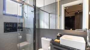 A modern bathroom with a glass-enclosed shower, a white toilet, and a large mirror above the sink. - Modern Studio in th Center of Florianopolis Ech504 (Florianópolis)