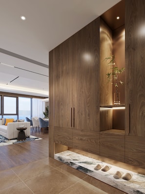 A modern living room with a large wooden cabinet, a dining area, and a view of the outdoors.