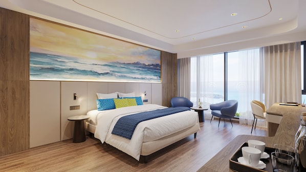 A modern hotel room with a large ocean view, a king-sized bed, a sitting area with a table, and a desk with a chair.