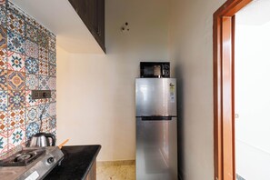 A kitchen with a stove, a refrigerator, and a tiled backsplash.