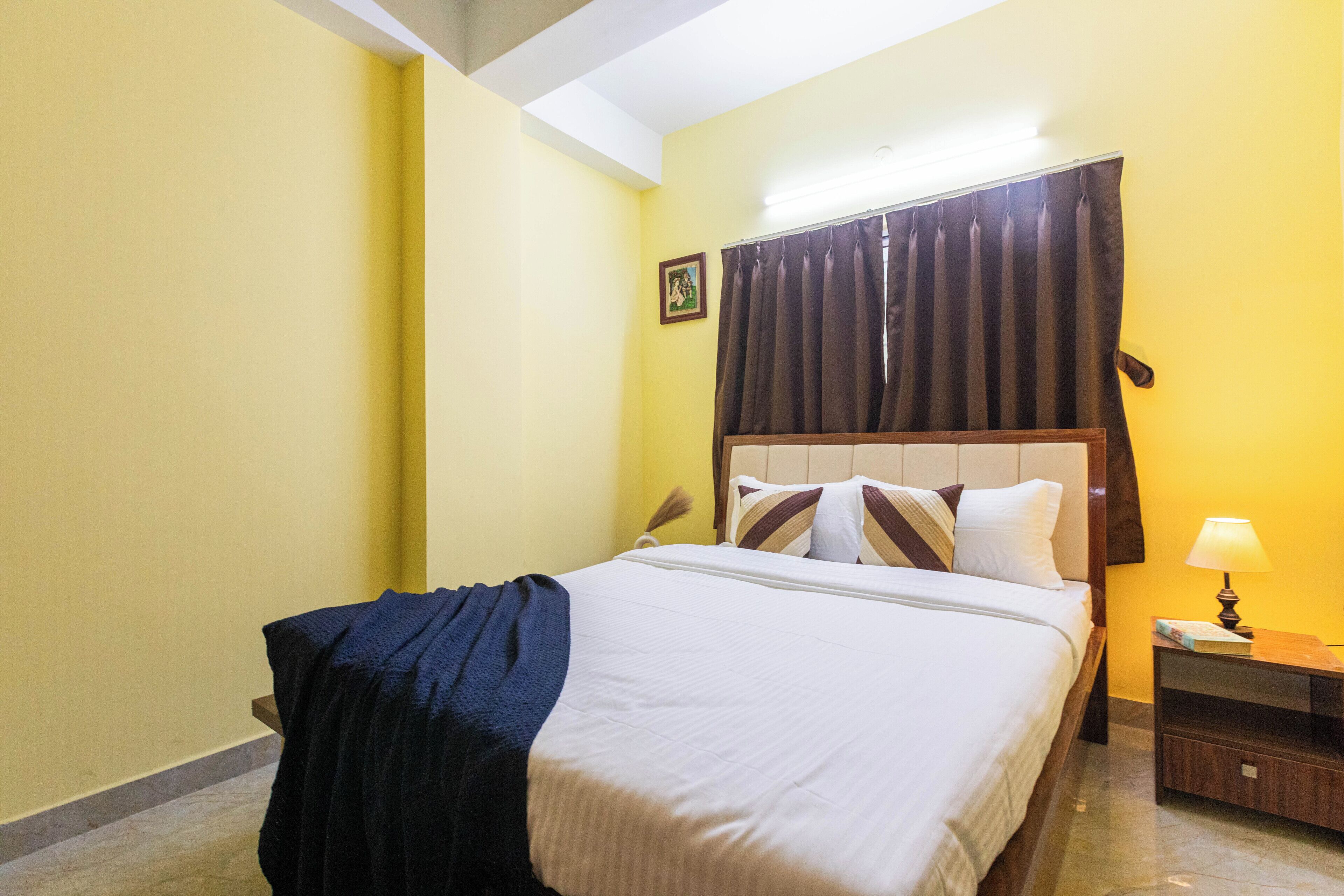 Une chambre d’hôtel avec un lit, une table de chevet, une lampe et un tableau au mur.