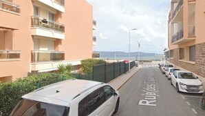 A street with parked cars and a building with balconies. - Exceptional location, 30 meters from the beach, right in the center, with air conditioning (Cavalaire-sur-Mer)