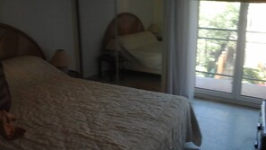 Une chambre à coucher avec un lit, une chaise et une fenêtre.