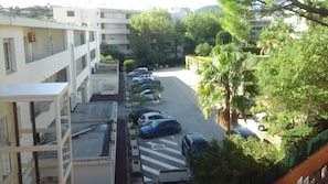 Ein mehrstöckiges Gebäude mit Parkplatz, umgeben von Grünflächen und Bäumen.