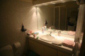 Ein Badezimmer mit Waschbecken, Spiegel und Toilettenartikeln.