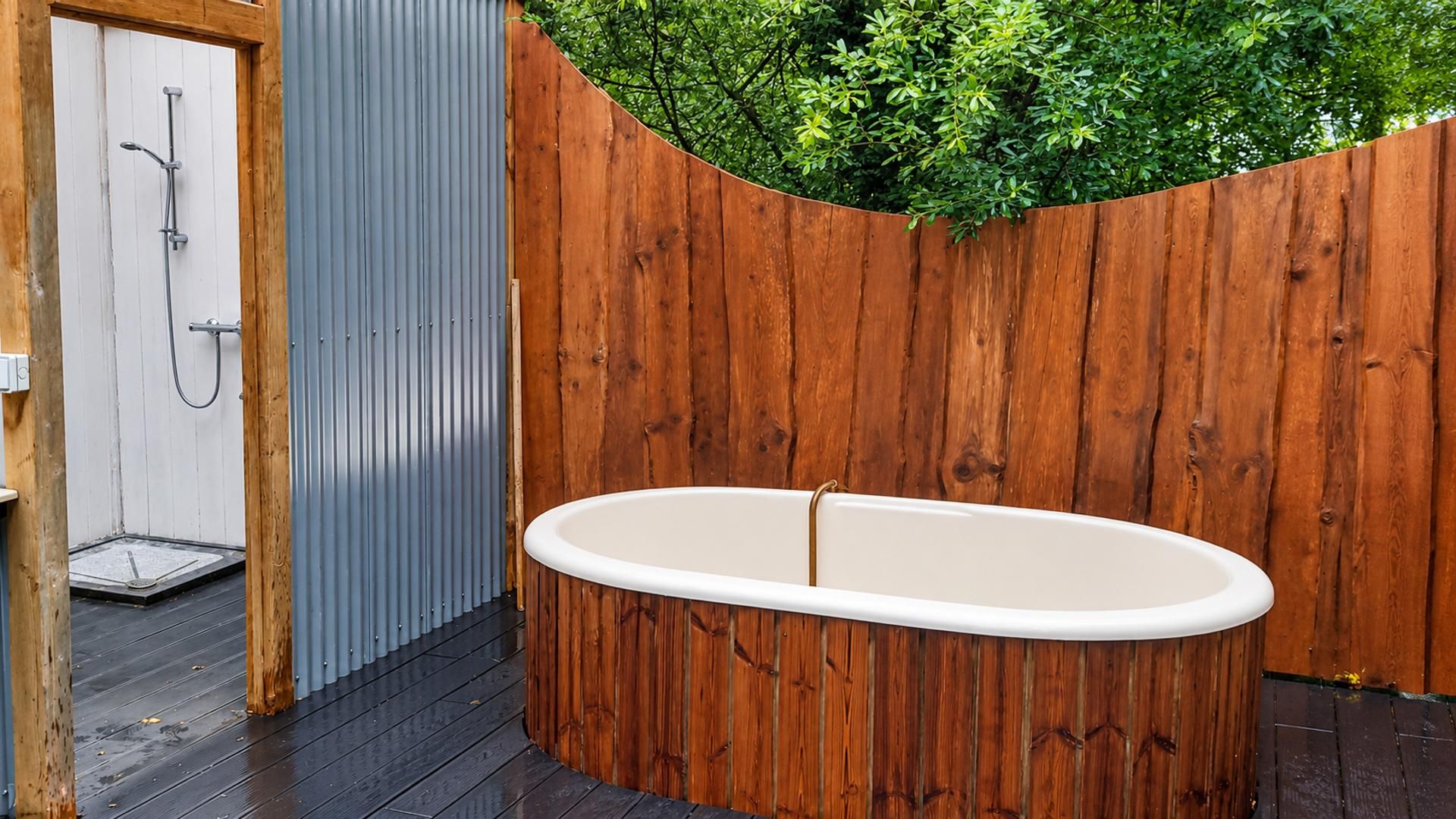 A wooden deck with a white bathtub and a shower.