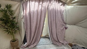 A room with a bamboo plant, a patterned rug, and a tent-like structure with purple curtains. - Pewsey Countryside Dome - Dog Friendly - Fire pit (Pewsey)