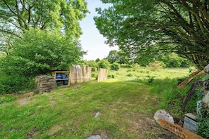 A rustic outdoor area with a wooden structure, a stone wall, and a sign indicating a location. - Sleeps 2 - Private Hot Tub - Fire Pit (Cardigan)