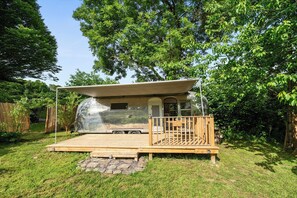 A transparent RV with a wooden deck and a covered porch. - Sleeps 2 - Private Hot Tub - Fire Pit (Cardigan)