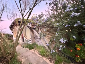 A rustic wooden structure with a large circular window and a wooden staircase leading up to it. - Coastal Cabin / 2 rooms / Sleeps 3 (Liverpool)
