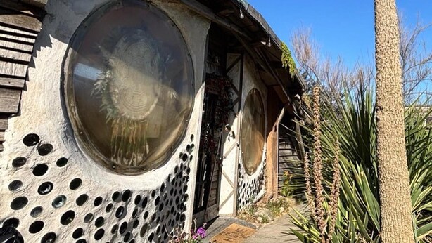 Een huis met grote ronde ramen en een houten gevel.