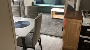 Um espaço compacto com cozinha compacta, área de refeições e sofá com almofadas.